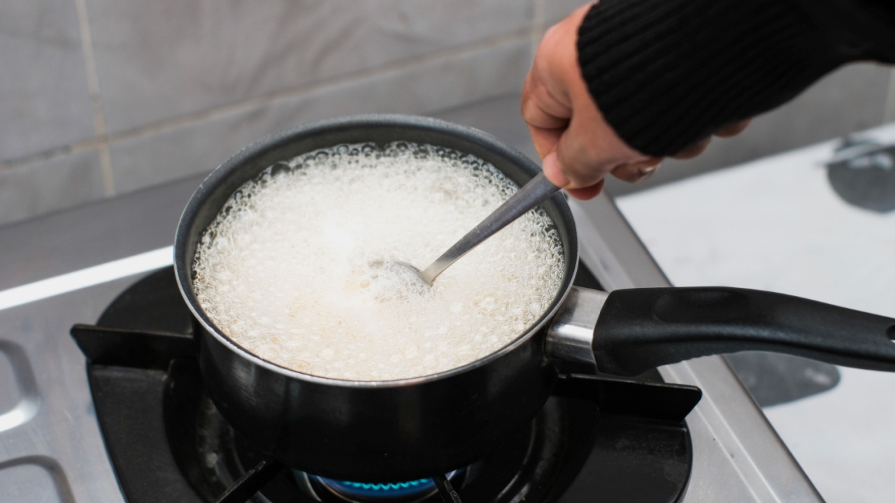 A women cooking the pasta macaroni or penne pasta in wok pan pot in boiling water, cooking pasta homemade.