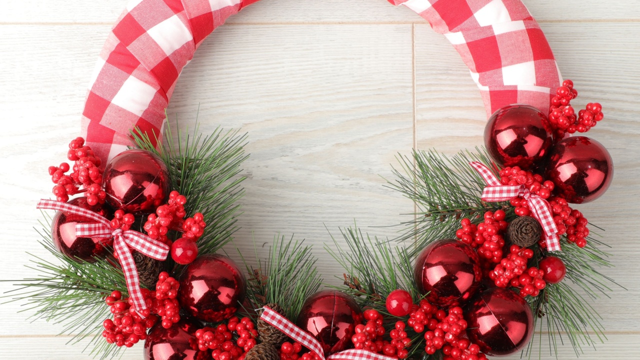 Christmas wreath over wooden background, closeup view. Xmas decoration.