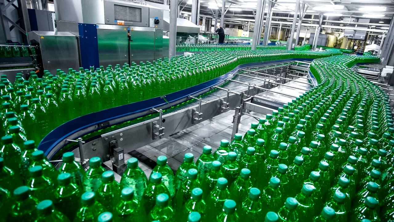 bright new factory line with plenty plastic green bottles with soda