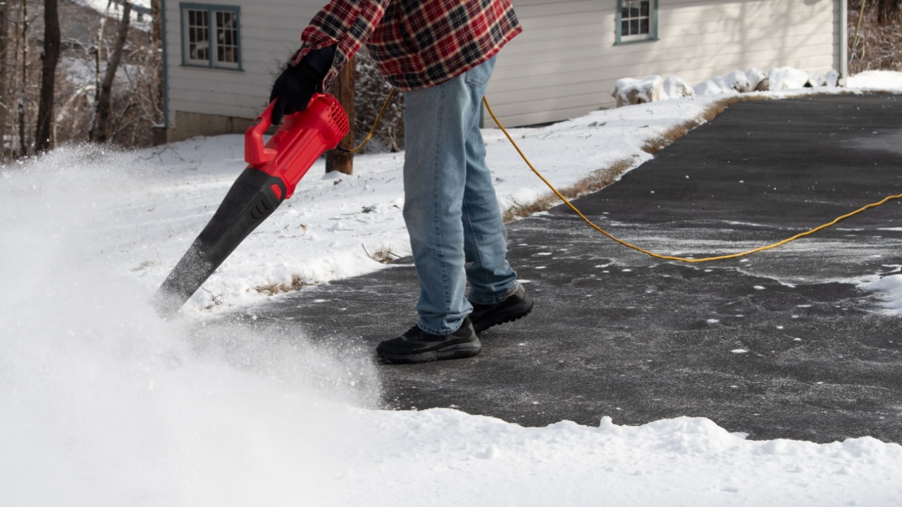 Using a leaf blower to clear light powdery snow from driveway