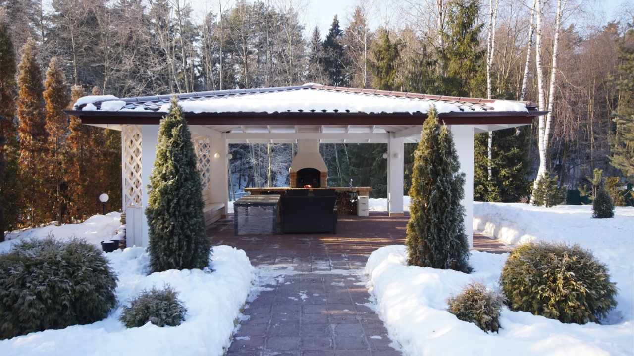 Private gazebo on the territory of the courtyard. Beautiful winter landscape against the blue sky. 