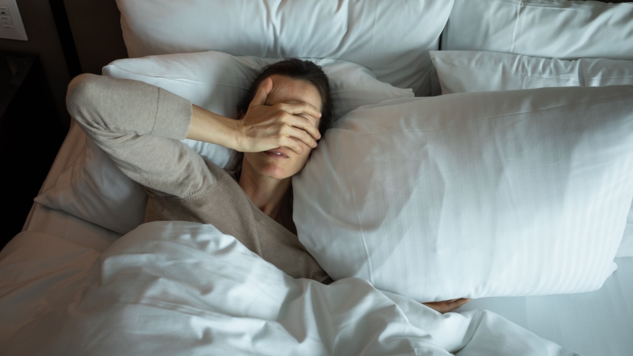 Sleepless woman suffering with insomnia lying in bed waking up tired