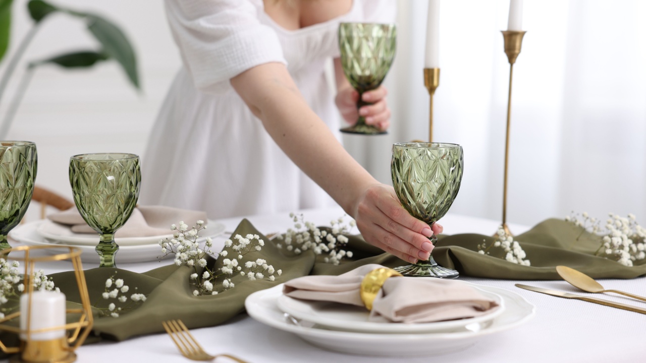 Young woman setting table for dinner at home, closeup