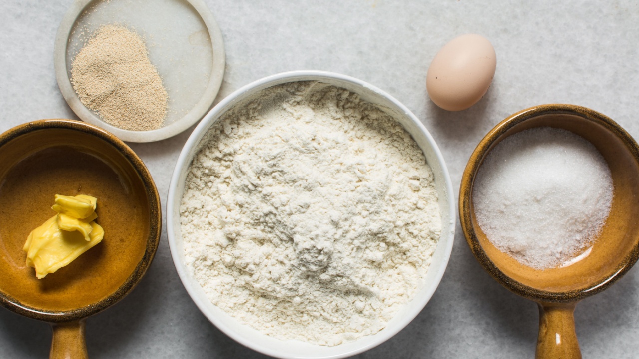overhead view of mise en place for homemade doughnuts, ingredients for making donuts on a marble countertop