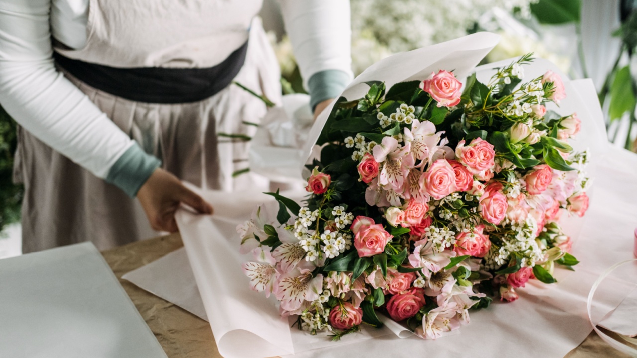 Floral bouquet of pink roses, alstroemeria, and babys breath laid on white paper before final wrap. Local florist, handmade business, bouquet crafting, fresh flower styling. High quality photo