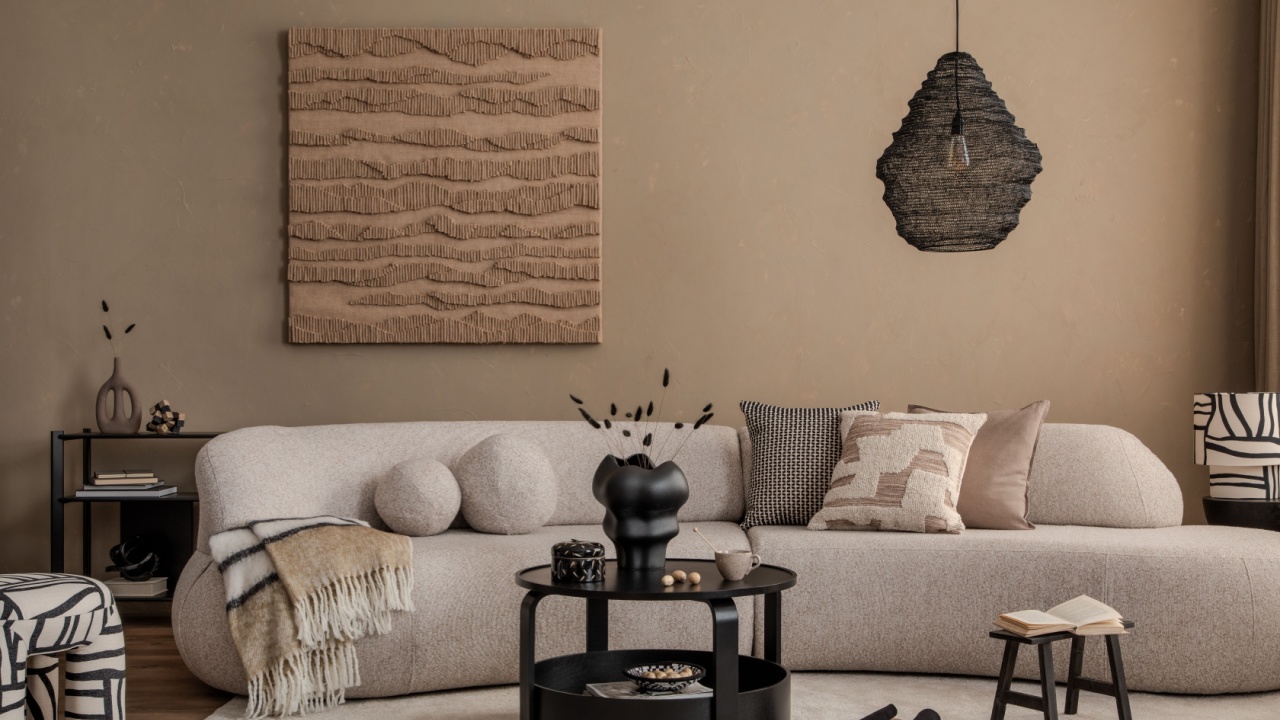 Stylish interior of living room with design sofa, art paintings and home decorations. Modern interior design.