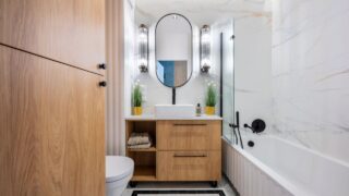 Modern bathroom interior with elegant marble wall tiles and a sleek bathtub.