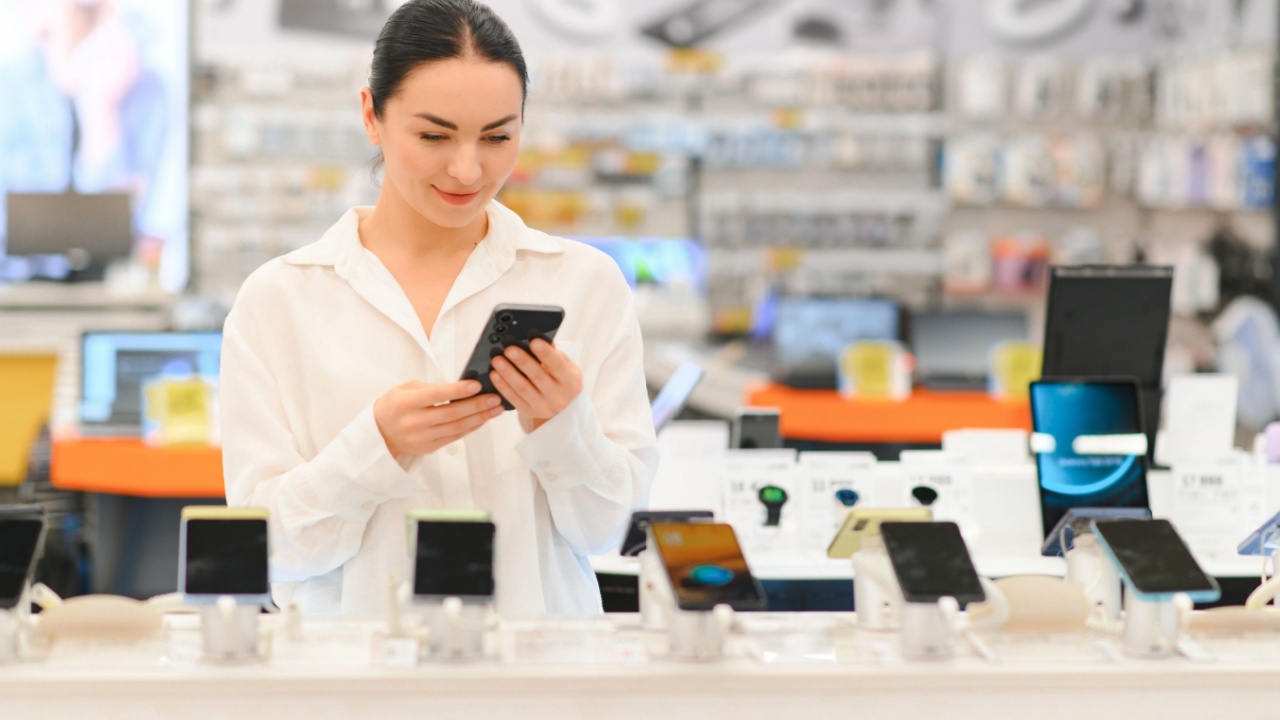 Buying new smart phone at tech store. Looking for a new peace of tech gadget.