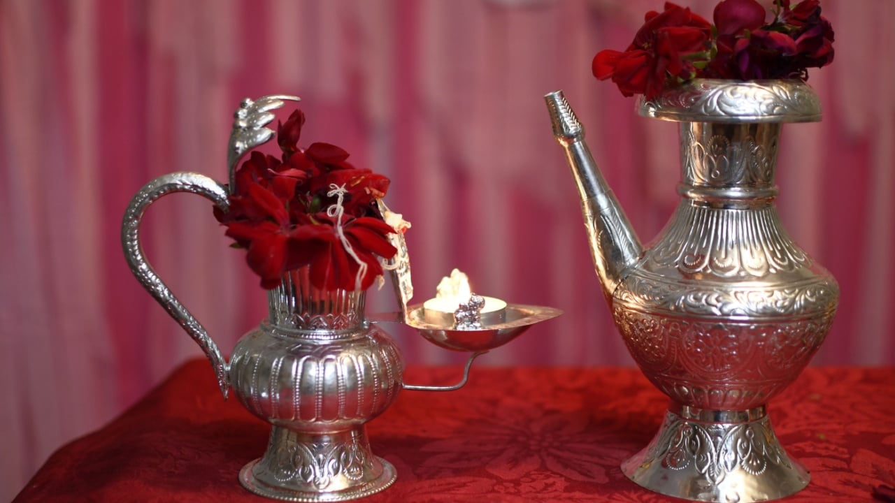 Tasmania, Australia - 04.27.2025 Silver plated traditional water pitcher with red flower.