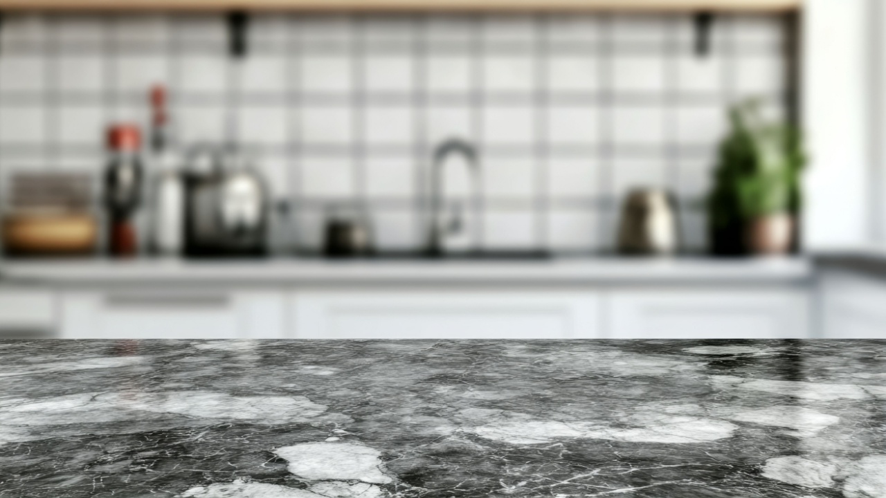 Modern kitchen countertop. Blurred background of a stylish, light gray kitchen with marble countertops and wooden shelves