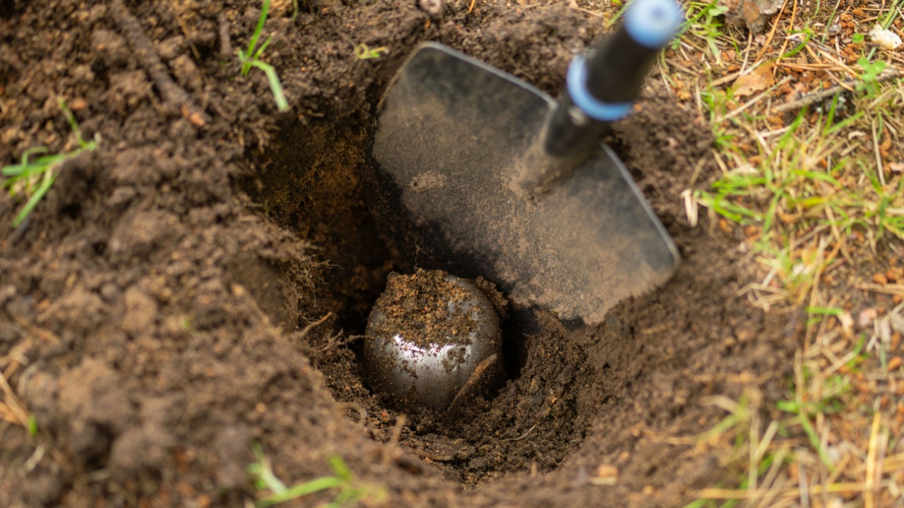 Bury a time capsule with a message in the ground. A metal can is sticking out of the ground.