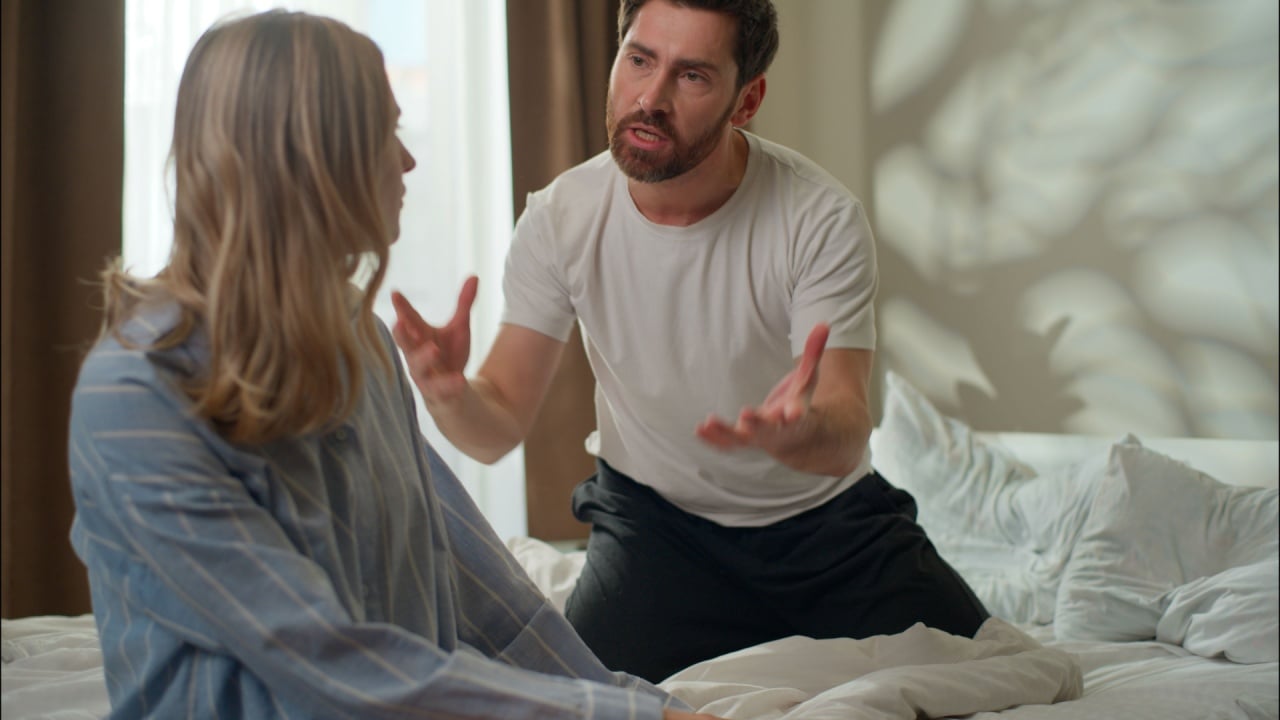 Upset Caucasian partners conflict arguing discussion in bedroom stressed couple dispute family frustrated wife talking pushing husband annoyed man shout woman disagreement relationship problem breakup