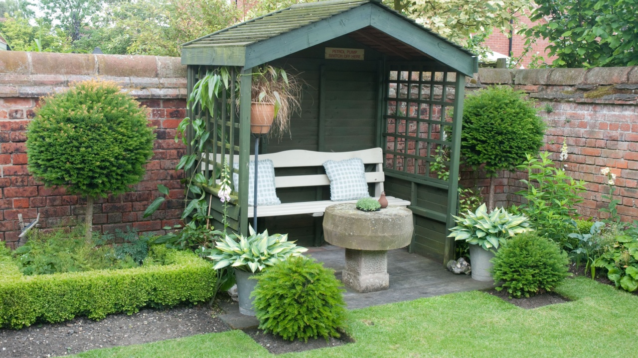 A tranquil garden nook features a wooden shelter, cozy seating, and manicured plants surrounded by lush greenery and brick walls.