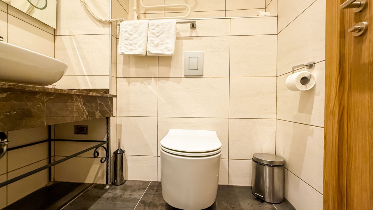 Full view of modern bathroom with sink, toilet, and mirror. Sanitation, hospitality, and comfort in travel accommodation.