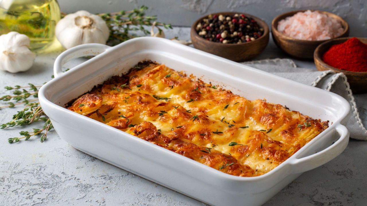 Potato gratin - graten (baked potatoes with cream and cheese) with rosemary and forks (Turkish name; Kremali patates)