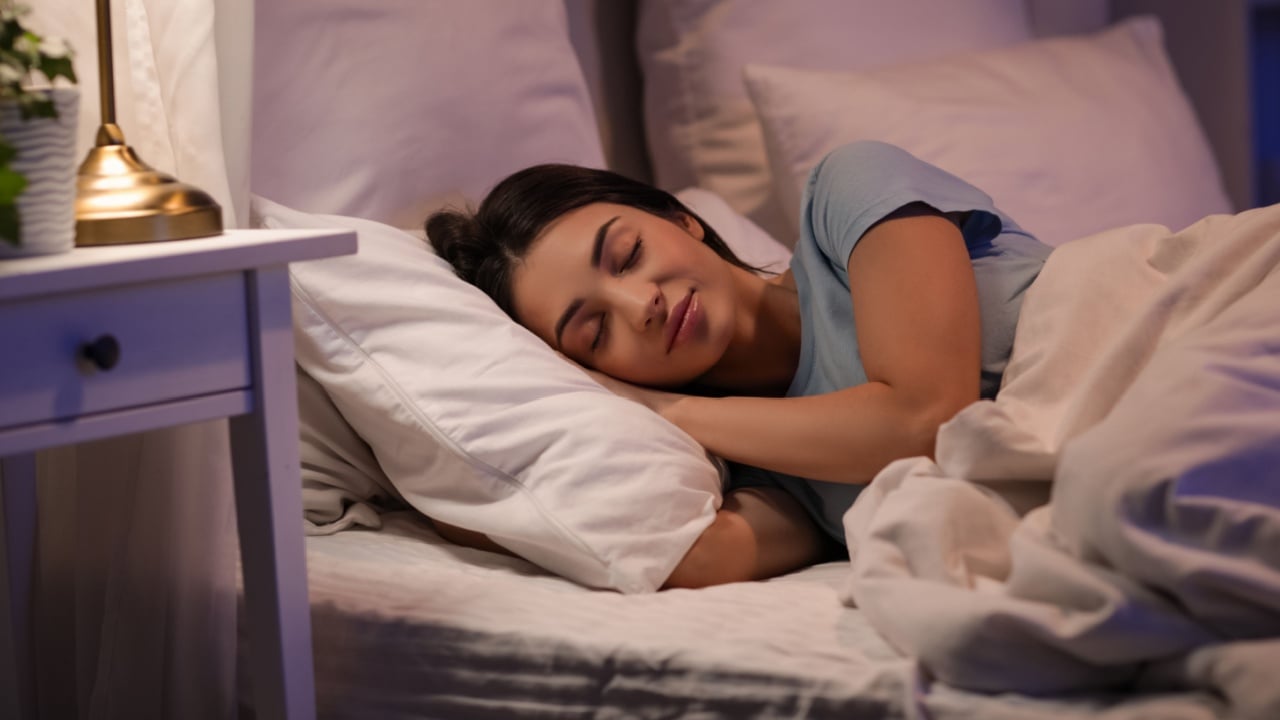 Young woman sleeping in bed at night