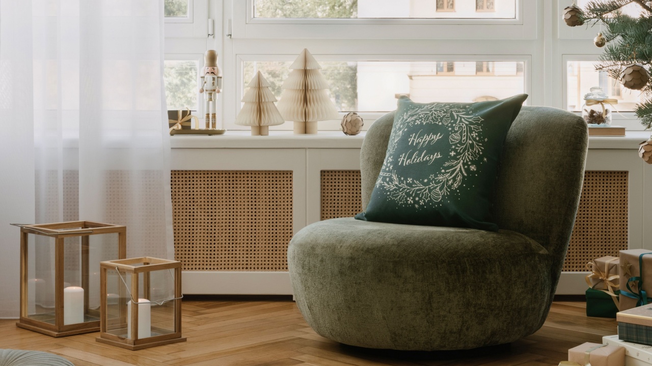 Bright window nook with green lounge chair, paper stars and white trees, gifts and a natural Christmas tree complete the serene holiday scene.