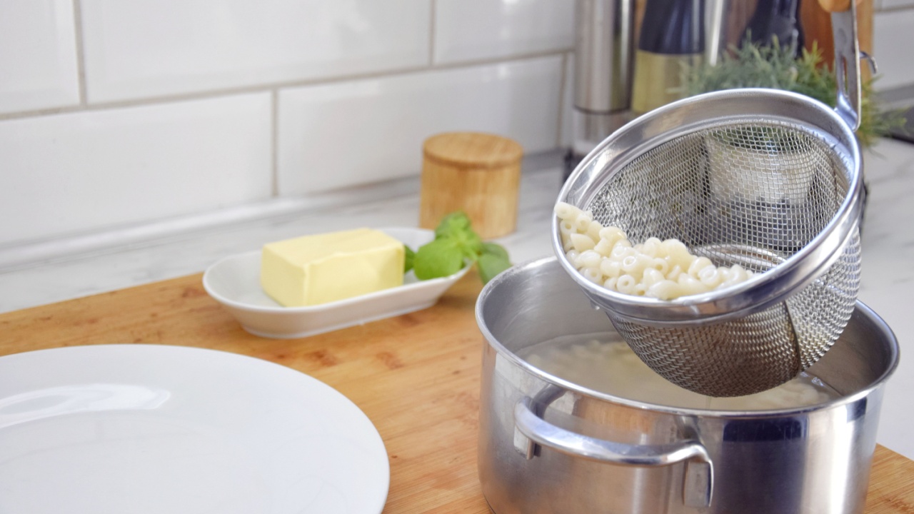 A person scoops up the cooked pasta with a special colander, where the water is immediately drained.