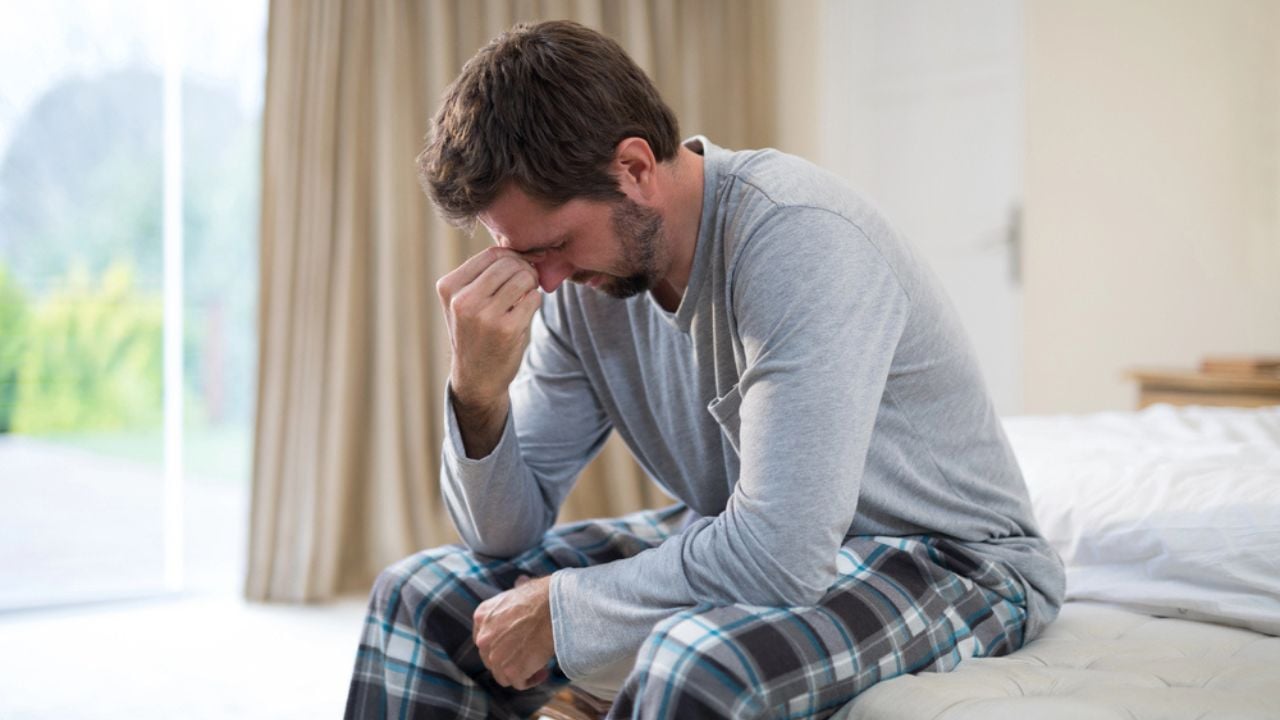Stressed man sitting on the bed