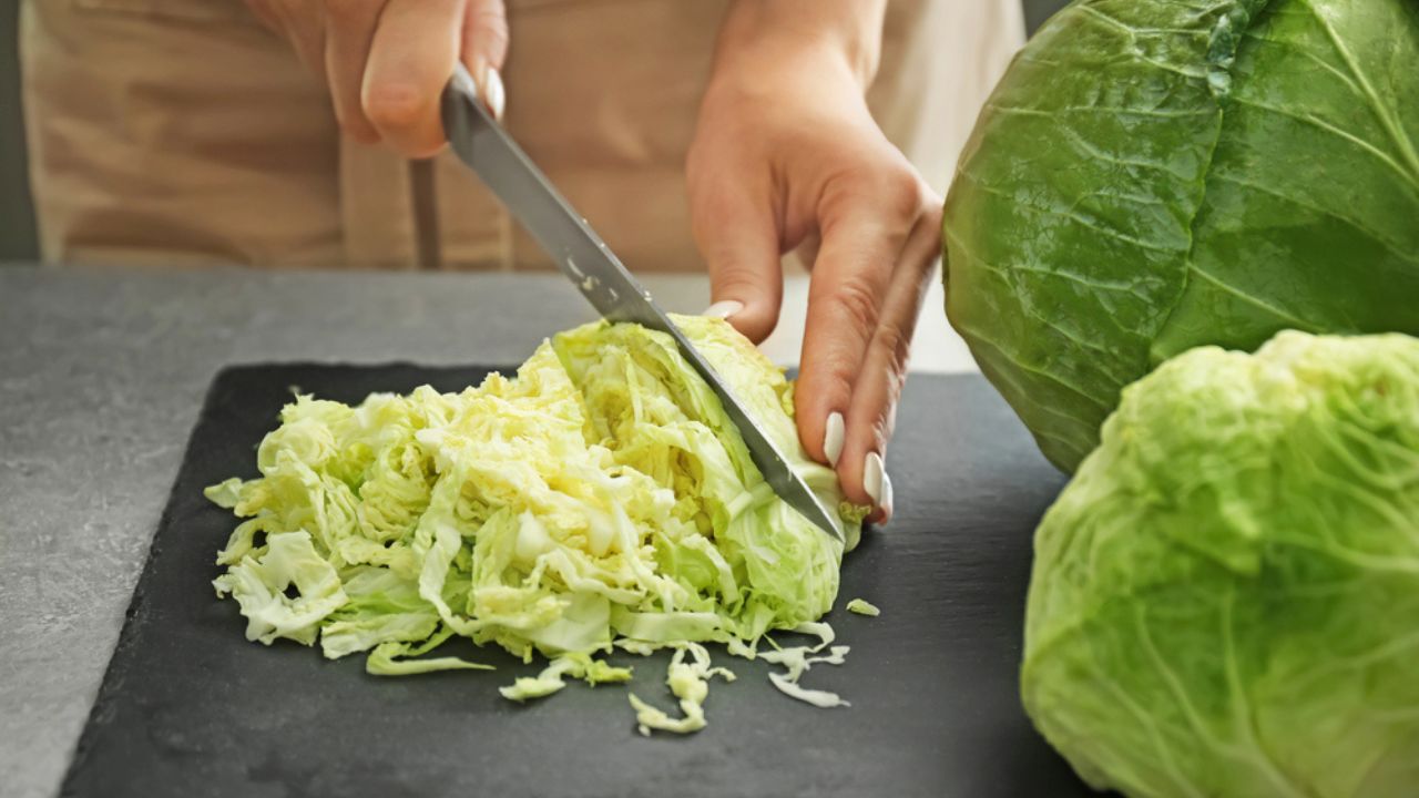 Woman cutting fresh cabbage