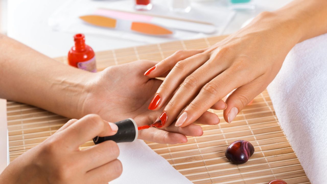 Woman in salon receiving manicure