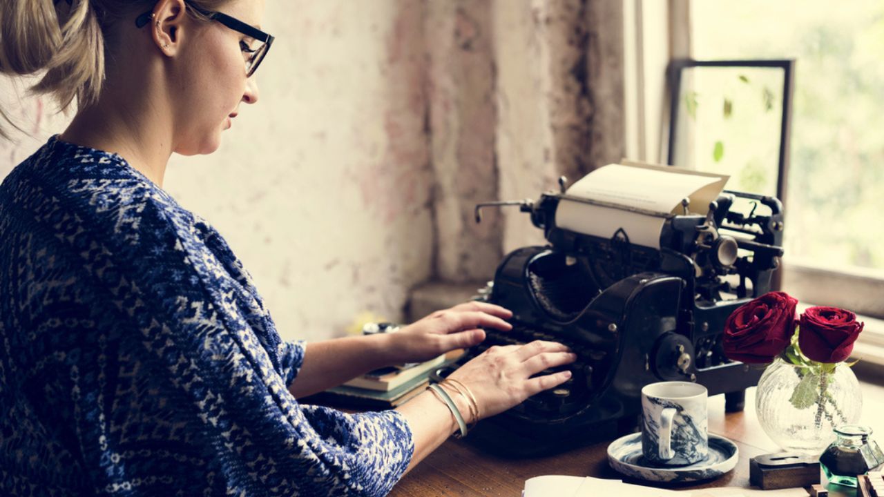 Woman typing on vintage typewriter