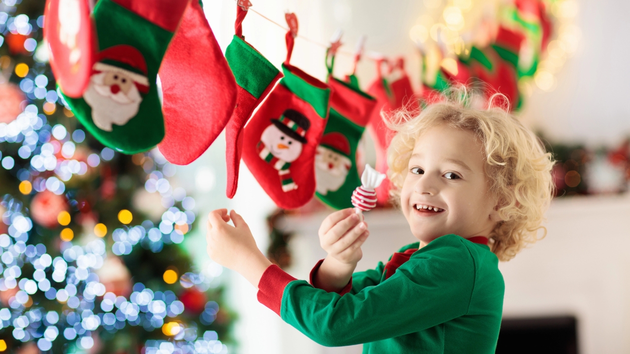 a little boy pulls a piece of candy out of an Advent calendar