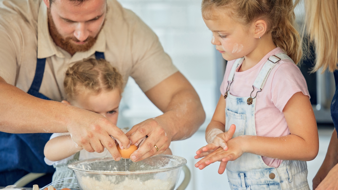 A dad with two little girls is baking