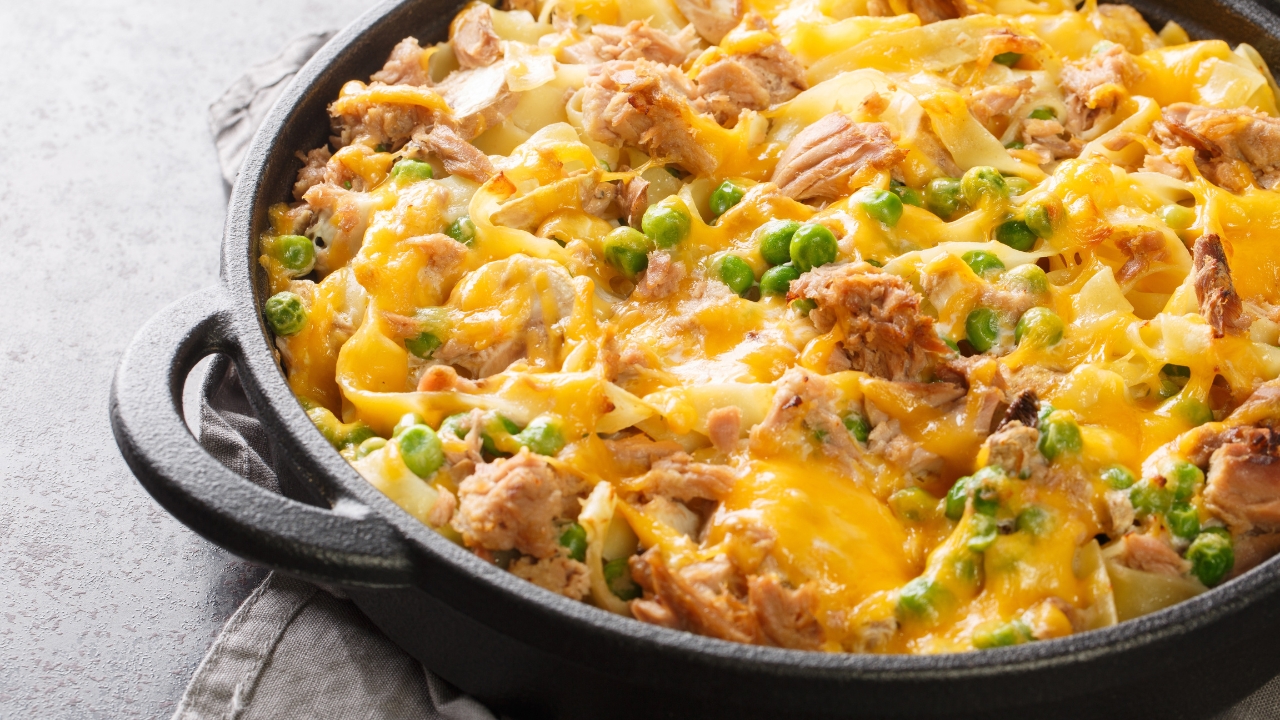 An iron pan filled with cheesy pasta and peas.