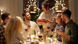 a family gathers around a Thanksgiving dinner table