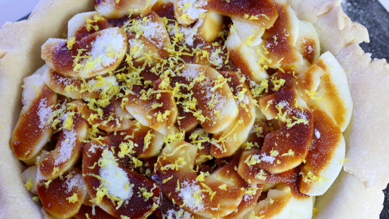 An unbaked apple pie made with molasses and lemon zest