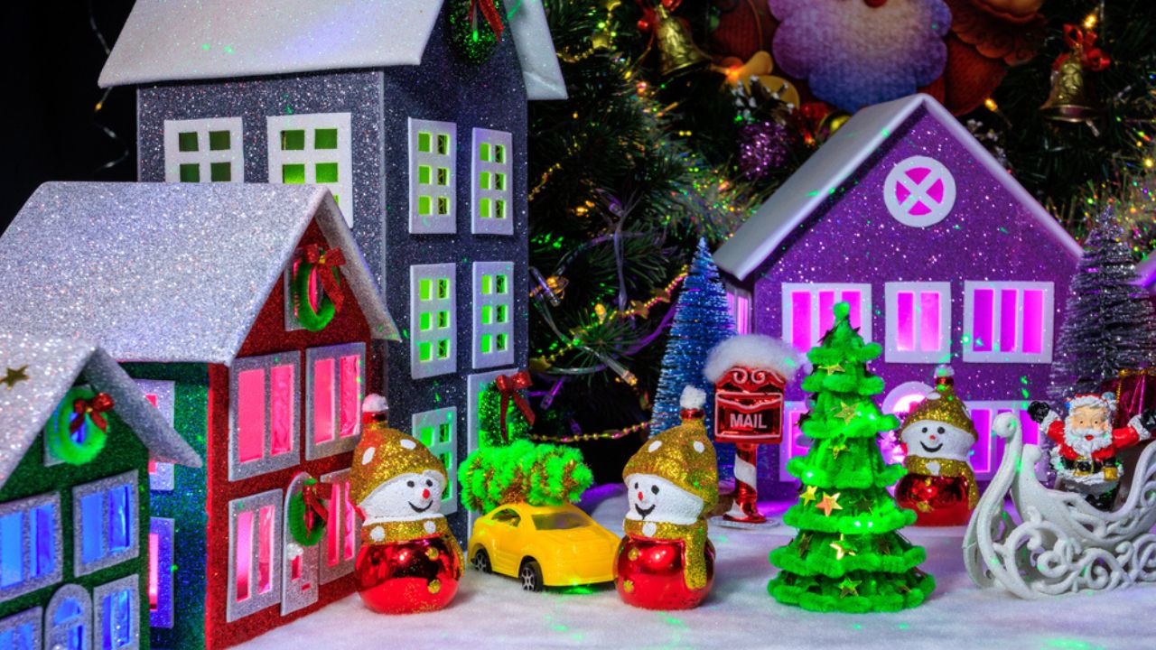 Among four decorated houses with bright lights in the windows,