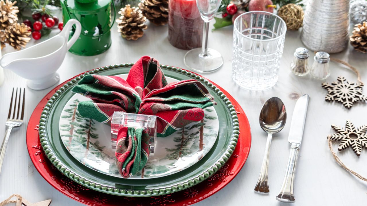 An elegantly decorated table setting in bright red in green for the winter holidays