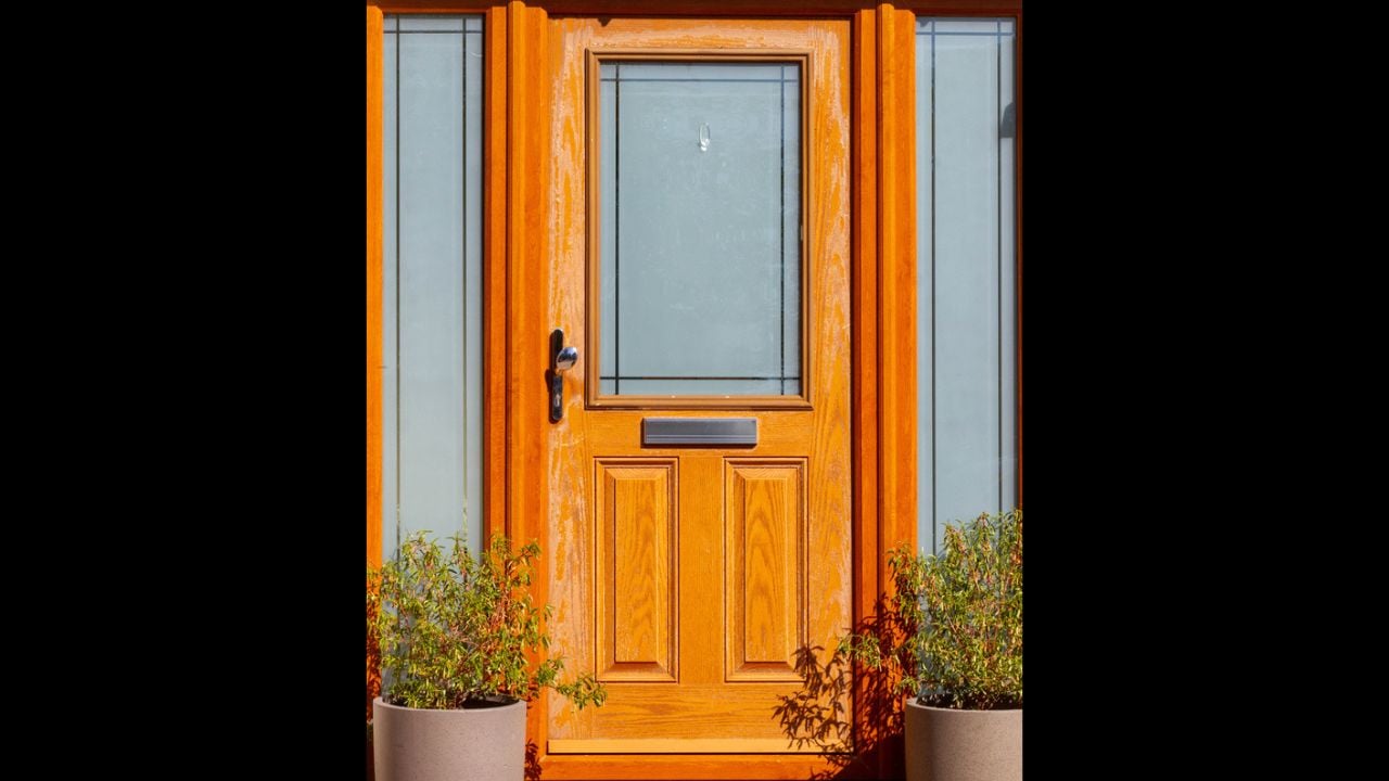 Beautiful warm modern wooden front door with the natural wood grain showing through and glass panels