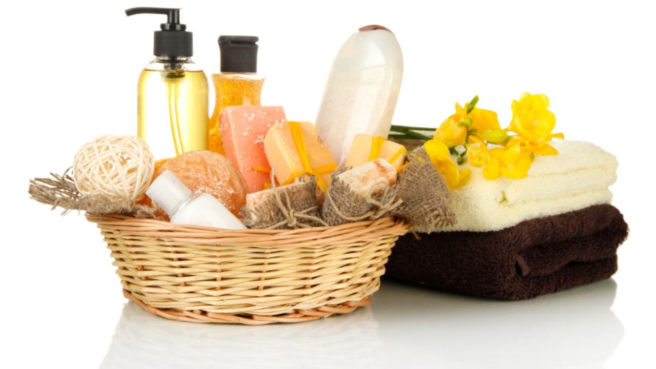 Composition of cosmetic bottles and soap in basket, isolated on white