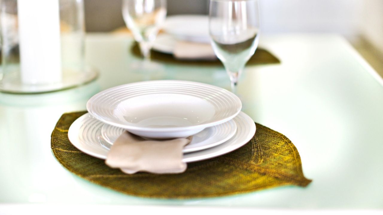Empty plates on a leaf design and glass with the table set up
