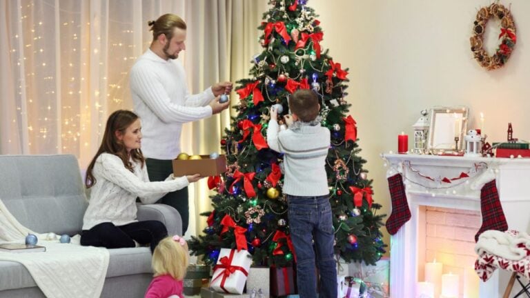 Family decorating Christmas tree in home holiday living room