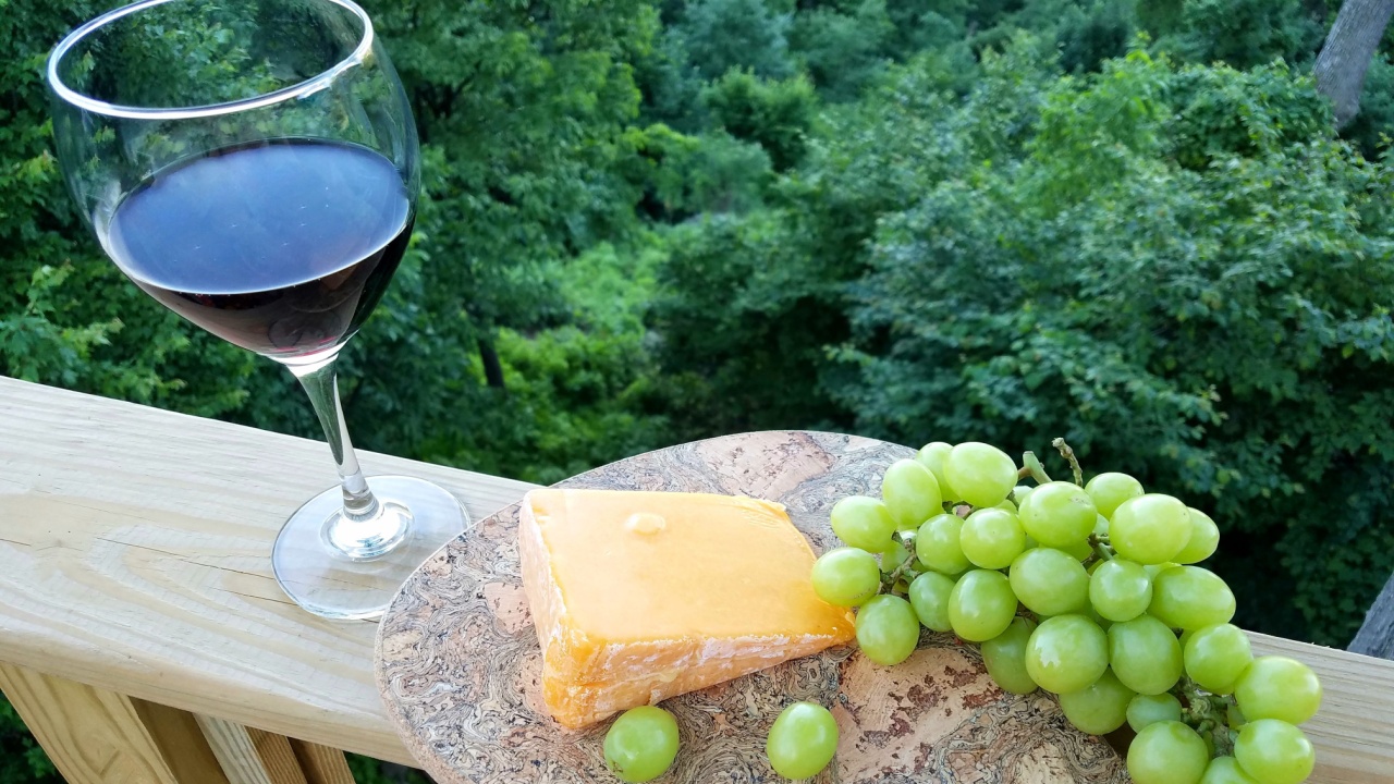 A Single Wine Glass Filled with Cabernet Sauvignon Along with Grapes and Cheese to Side