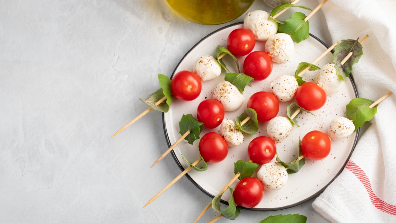 Caprese salad - skewer with tomato, mozzarella and basil, italian food and healthy vegetarian diet concept on a light background. Top view with copy space. Flat lay