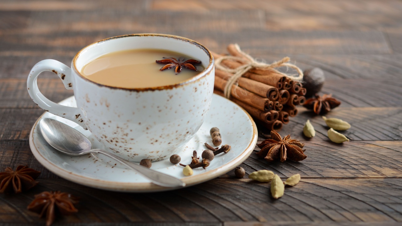 Indian masala chai tea. Masala chai spiced tea with milk and spices in a vintage cup on a rustic wooden table.