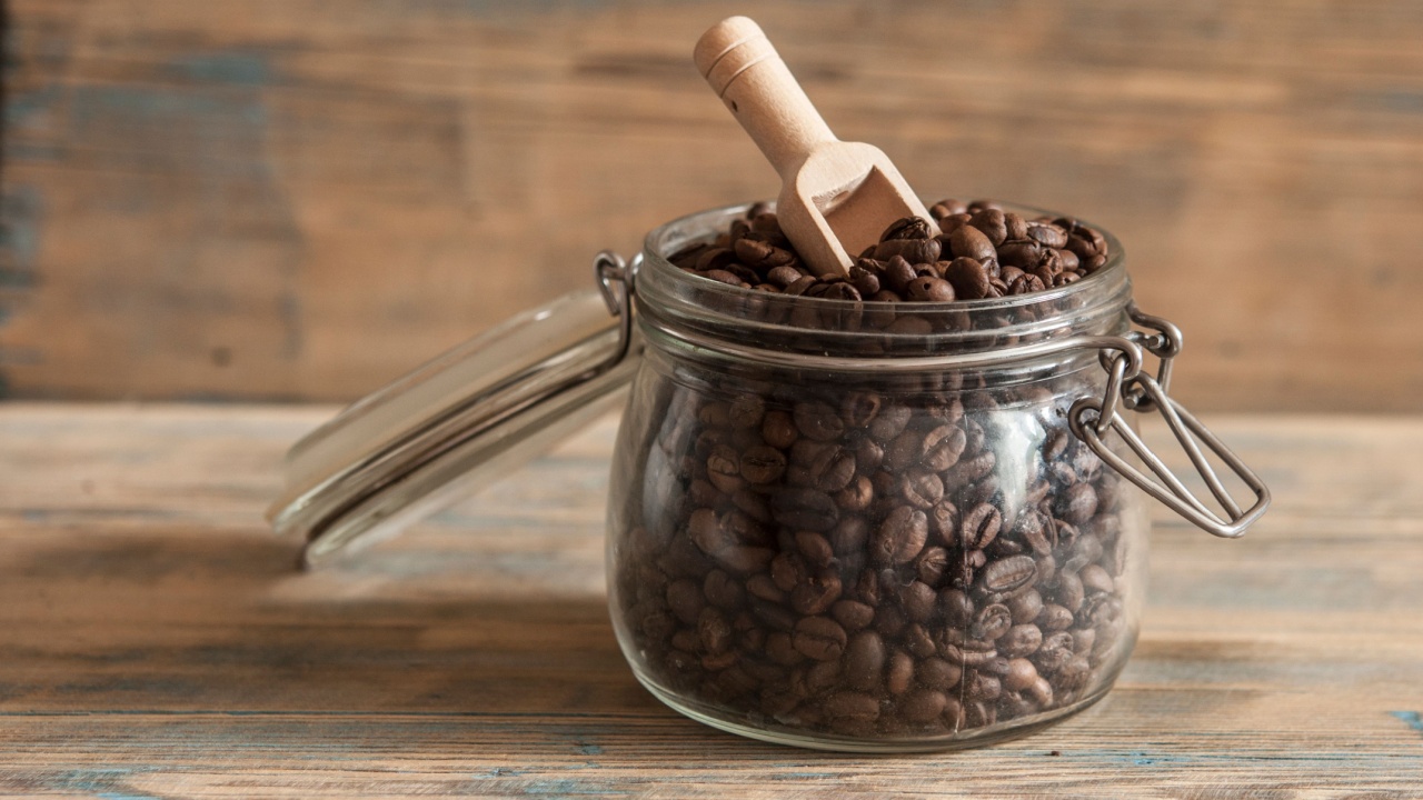 Roasted coffee beans in glass jars on wood table