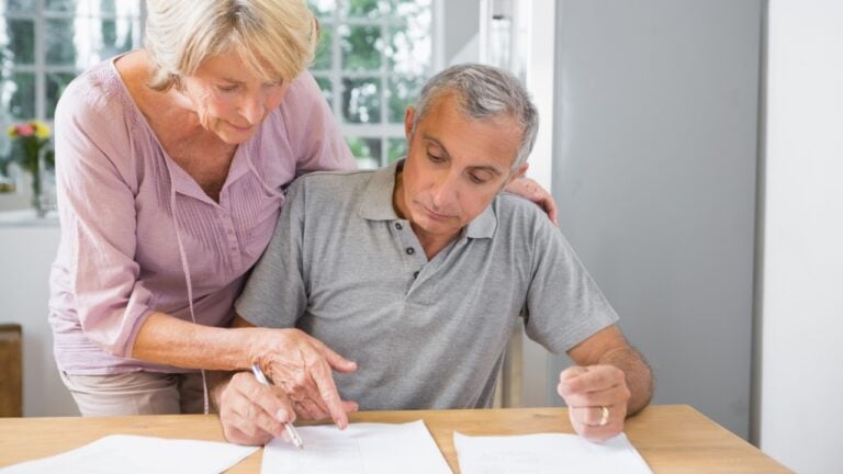Wife showing where to sign to her husband in the kitchen