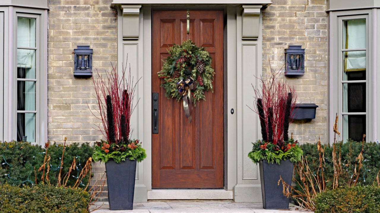 wooden front door with wreath and seasonal decorations