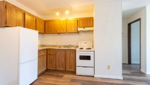 An empty vacant rental apartment property with new hardwood laminate floors and white paint on the walls.