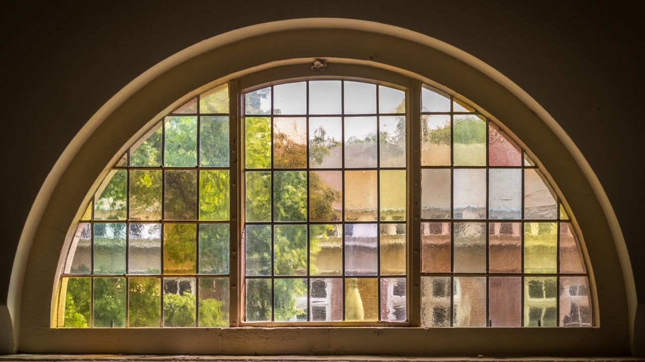 stained glas in a half circle wooden frame