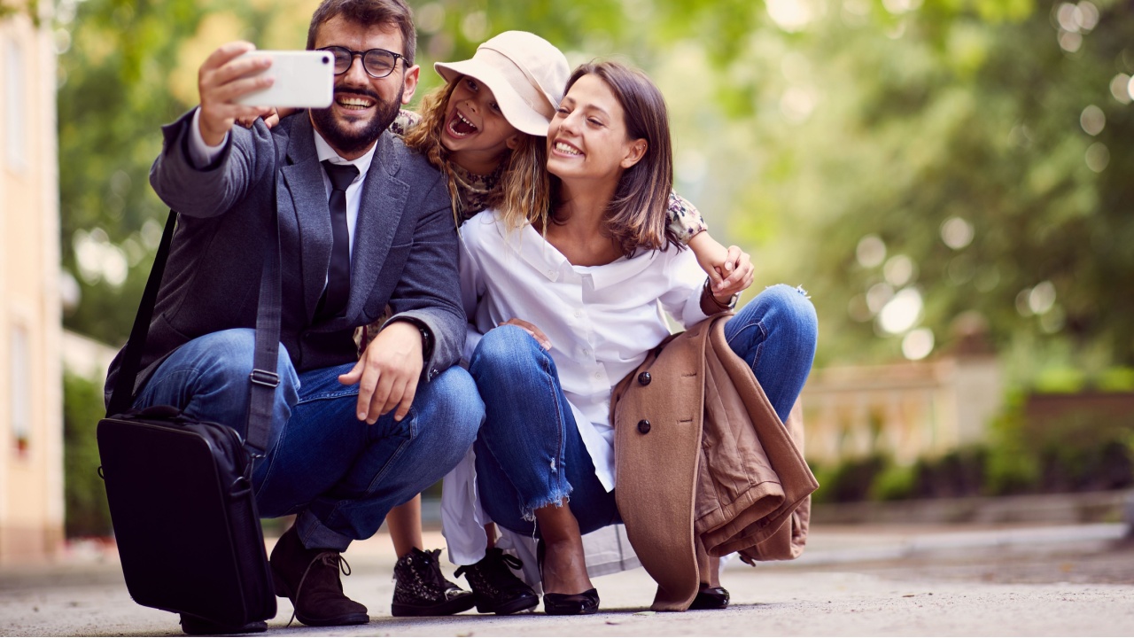 smiling family taking photo of them after first day of school