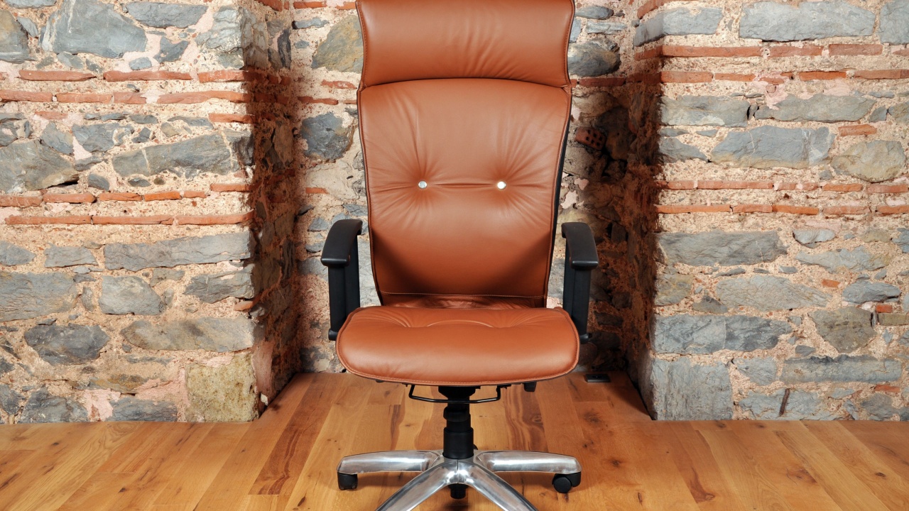 Comfortable and stylishly designed brown office chair in front of a wall
