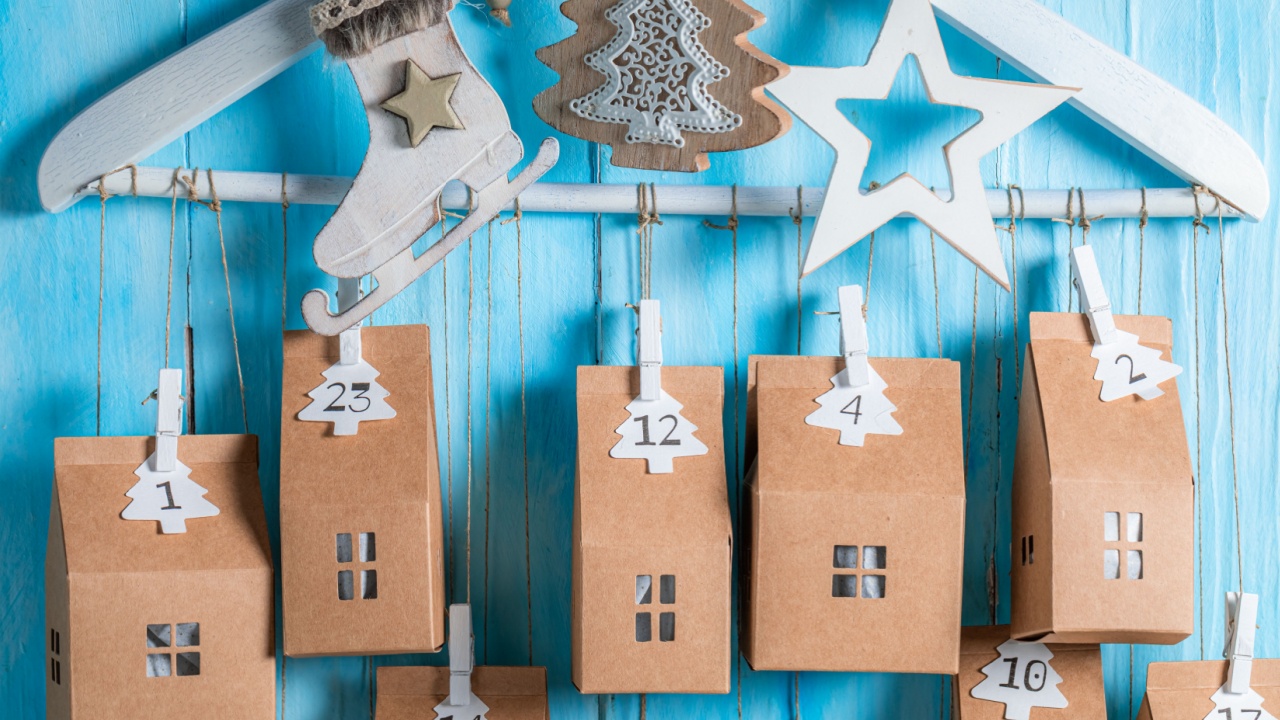 Cute Christmas Advent Calendar as small house with a number on blue wooden background