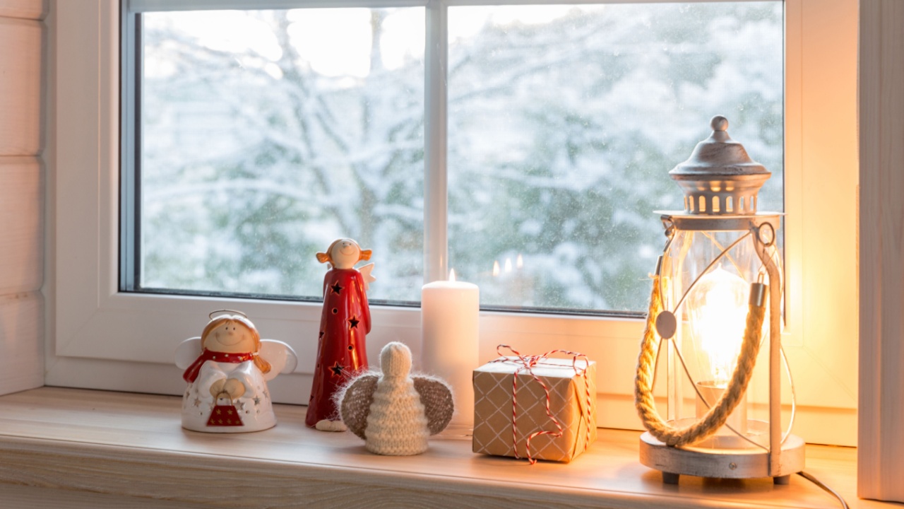 Christmas lantern, angels with gifts on the window of a wooden house overlooking the winter garden at night in winter.
