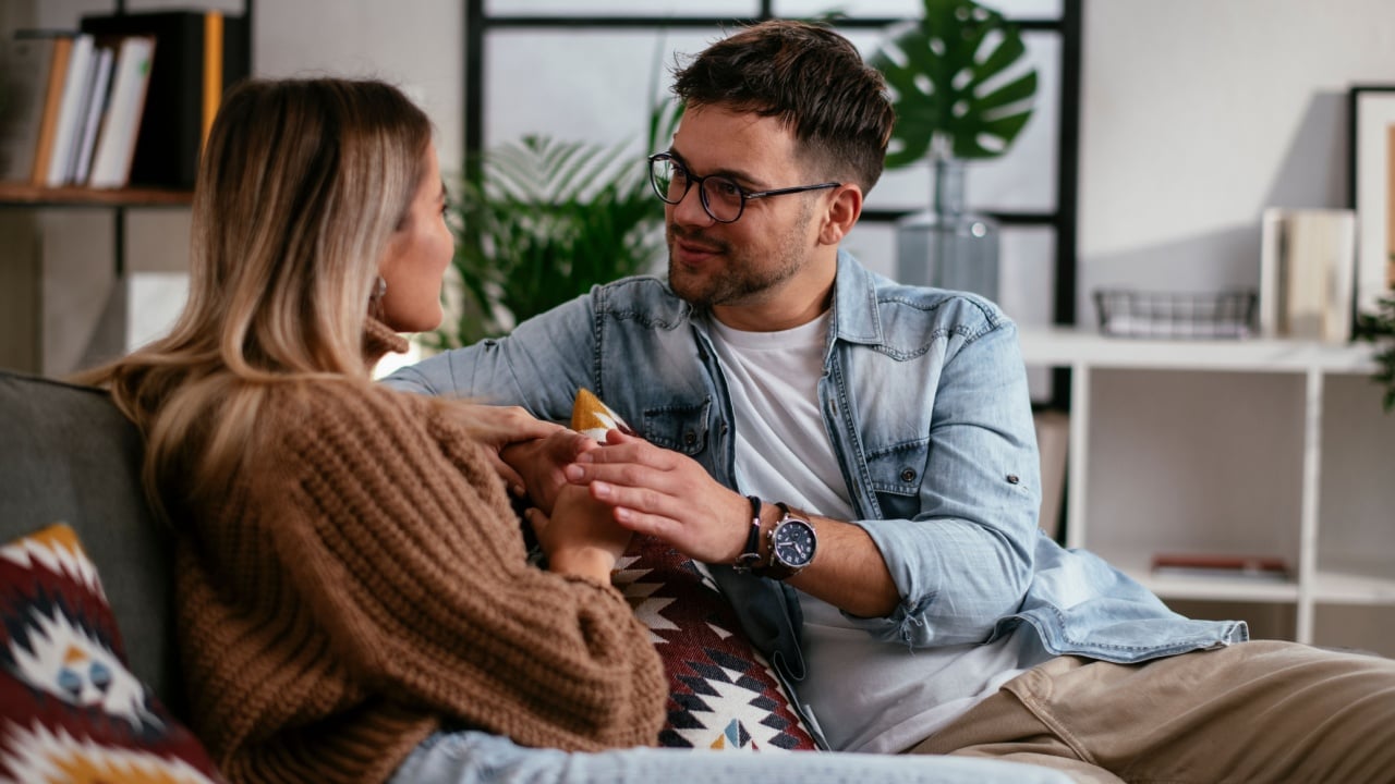 Young couple sitting and talking at home. Loving couple on date.